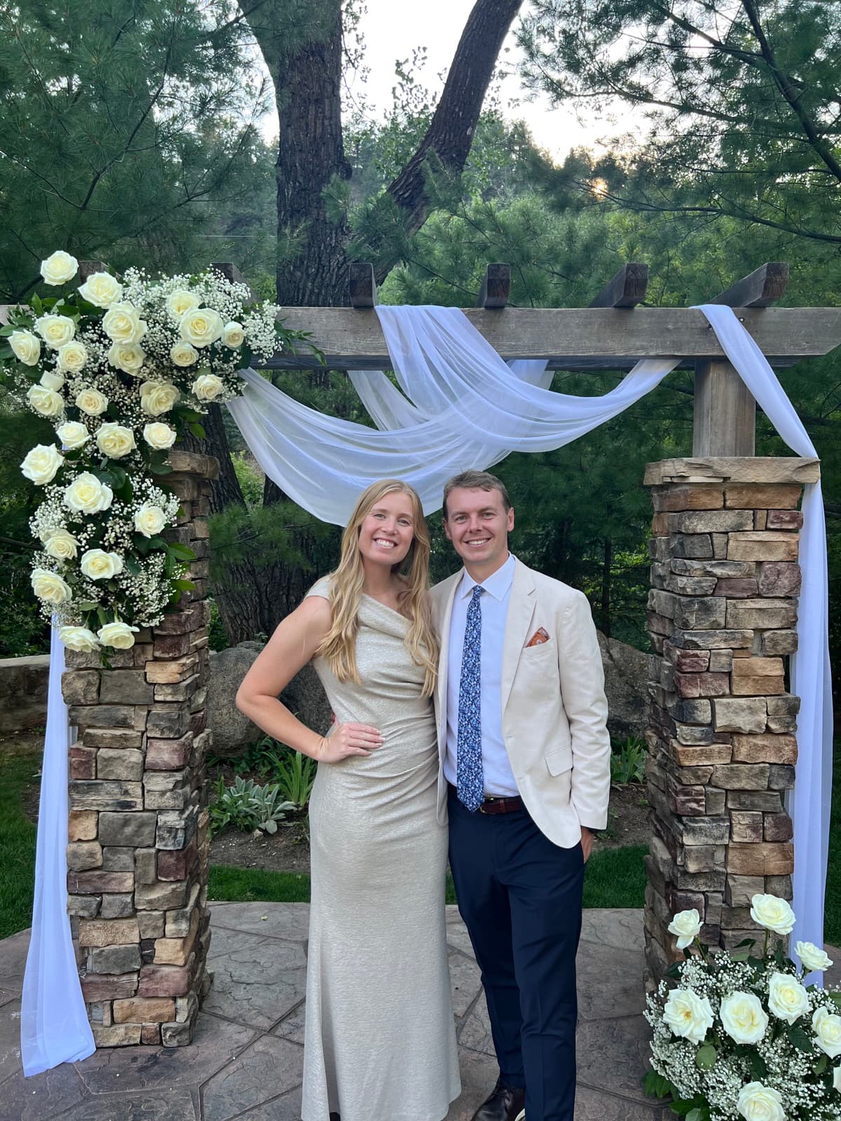 Kaitlyn and Chris dressed up beneath a flower-covered garden arch
